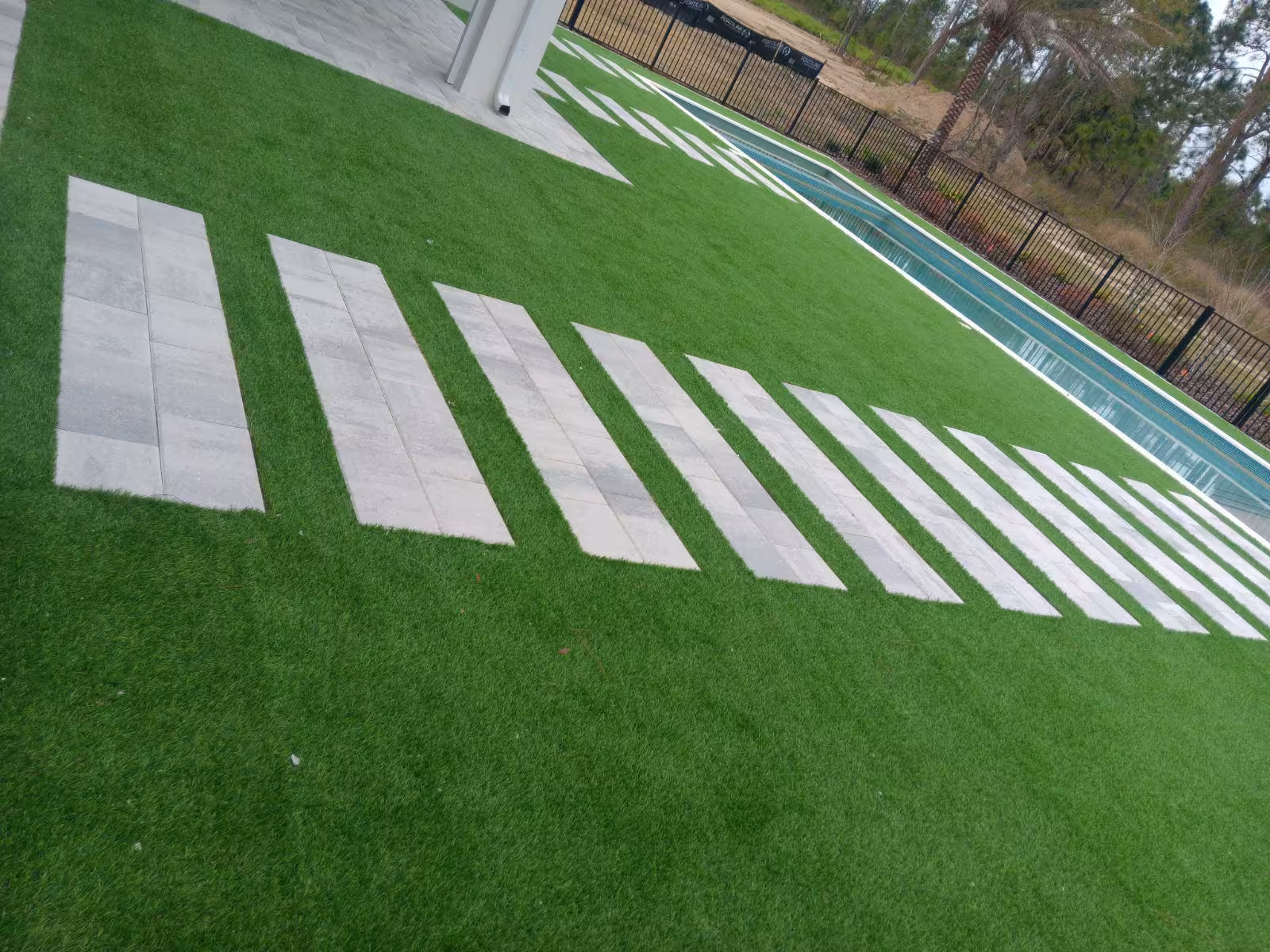 Stepping stone pathway with artificial turf and pool area