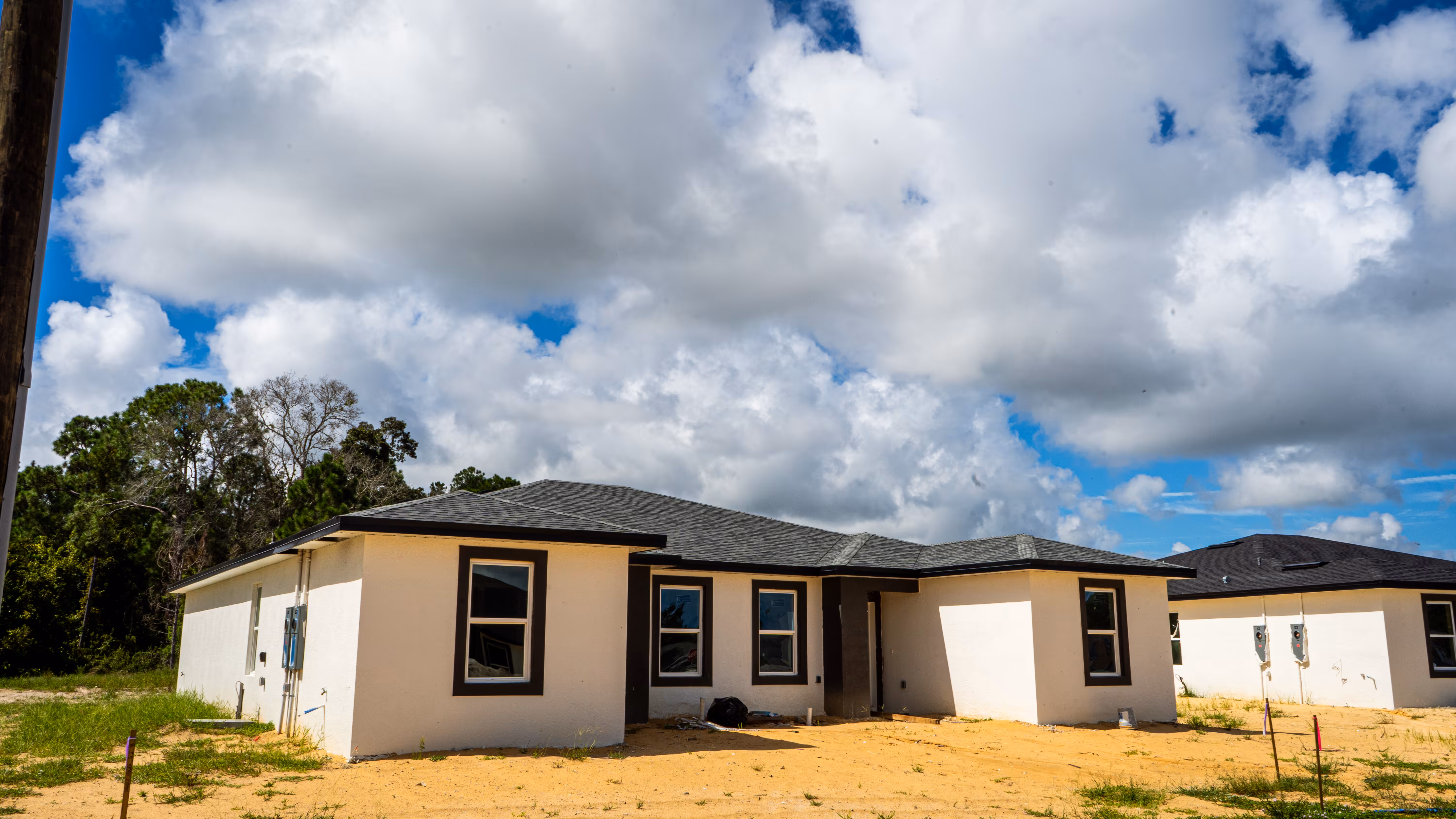 New home construction in progress, stucco exterior with shingle roof
