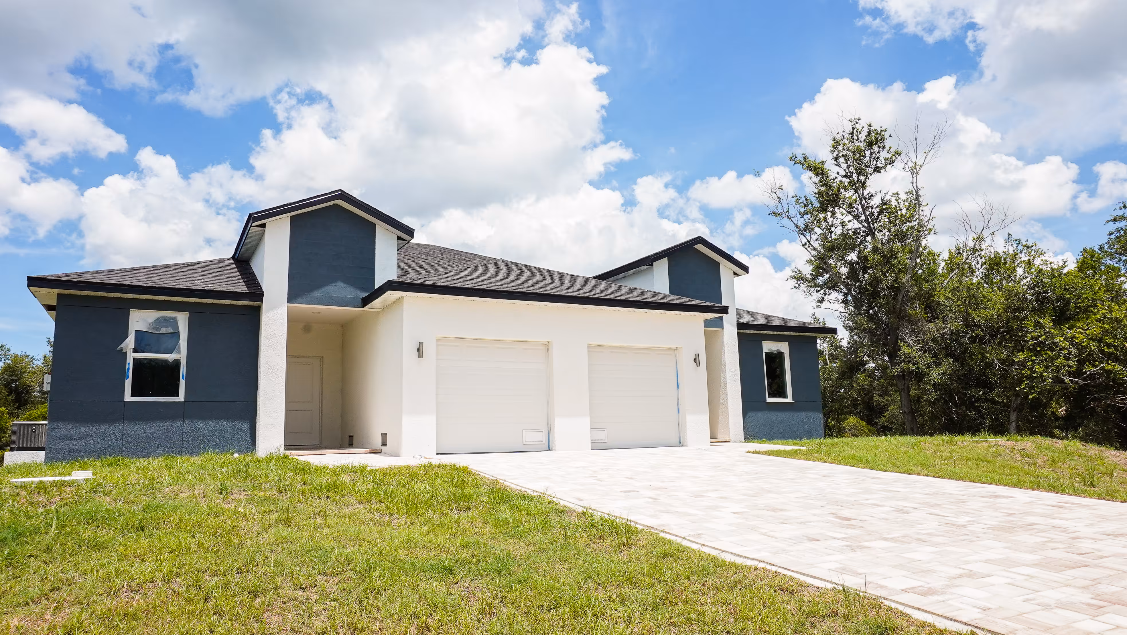 Completed custom home with 2-car garage and paver driveway